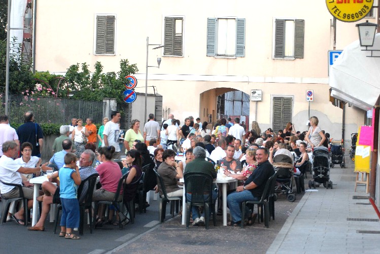 Foto di Via Carducci con famiglie a cena durante la notte bianca